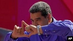 El presidente de Venezuela, Nicolás Maduro, saluda a simpatizantes desde el escenario durante un mitin por el Día del Trabajador en Caracas, el 1 de mayo de 2022.