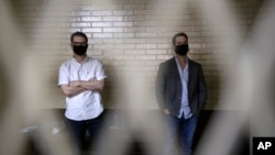 Luis Enrique Martinelli Linares, a la izquierda, y Ricardo Martinelli Linares, hijos del expresidente de Panamá, Ricardo Martinelli, esperan en una celda en Ciudad de Guatemala, el 7 de julio del 2020.