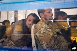 Ukrainian servicemen sit in a bus after they were evacuated from the besieged Mariupol Azovstal steel plant, near a remand prison in Olyonivka, in territory under the government of the Donetsk People's Republic, eastern Ukraine, May 17, 2022.