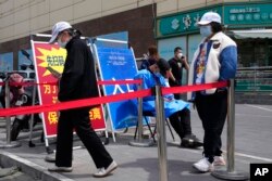 រូបឯកសារ៖ ប្រជាជន​ចិន​ឈរ​តម្រង់ជួរ​ដើម្បី​ធ្វើ​តេស្ដ​រក​ជំងឺ​កូវីដ១៩ ក្នុង​ទីក្រុង​ប៉េកាំង ប្រទេស​ចិន ថ្ងៃទី ១២ ខែឧសភា ឆ្នាំ២០២២។