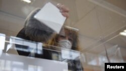 Žena glasa na izborima u Beogradu, 3. aprila 2022. (Foto: Reuters/Zorana Jevtić)
