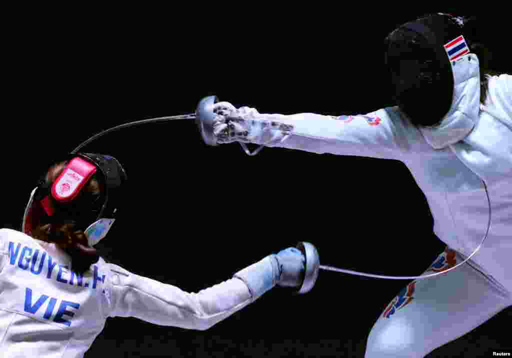 Vietnam's Phuong Kim Nguyen competes against Thailand's Pacharaporn Vasanasomsithi during the Women's Espee Team semi final fencing event at the SEA Games in Hanoi, Vietnam.