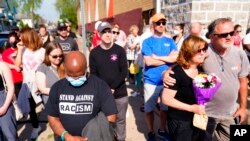 La gente se reúne fuera de la escena de un tiroteo en un supermercado en Buffalo, N.Y., 15 de mayo de 2022.