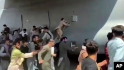 Архівне фото: люді в Афганістані біжать за транспортним літаком США C-17 на злітній смузі в Кабулі, 16 серпня 2021 року