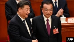 资料照片: 2023年3月11日中国国家主席习近平(左)与前总理李克强(右)握手