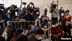 FILE - Members of the media work at the West Kowloon Magistrates' courts in Hong Kong, China, Nov. 25, 2022.