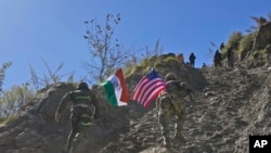 2022年11月30日，印度和美國陸軍士兵舉著各自國家的國旗，在印美聯合演習期間跑上一座小山。(美聯社照片）