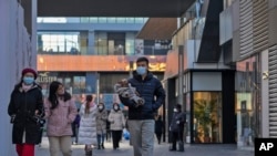 خەڵک بەناو مۆڵێکی بازرگانی کراوەدا دەڕۆن لە پەکین، ٤ی مانگی 12ی ساڵی 2022.