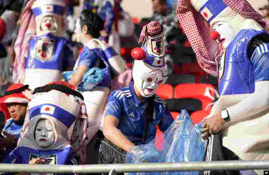 Japanese fans clean the stadium's stand after Japan was defeated by Costa Rica in the World Cup, group E soccer match between Japan and Costa Rica, at the Ahmad Bin Ali Stadium in Al Rayyan , Qatar.