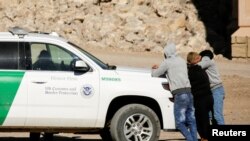 Migrantes cubanos son detenidos por un agente de la Patrulla Fronteriza de EEUU cuando se entregan para solicitar asilo, después de cruzar a El Paso, Texas, EE. UU., visto desde Ciudad Juárez, México, el 5 de febrero de 2021.