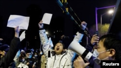 2022年11月28日，在新冠病毒疫情持續擴散之際，北京民眾為烏魯木齊火災遇難者守夜後，舉著白紙抗議中共當局的封控限制。