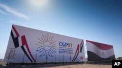 El logotipo de la Cumbre Climática de las Naciones Unidas COP27 y la bandera egipcia se muestran en una valla publicitaria que bordea una carretera recién construida en Sharm el-Sheikh, Egipto, el 5 de noviembre de 2022.