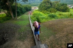 Fisherman Marco Aurelio Cauto Viana, carries pieces of a pirarucu fish in San Raimundo settlement, at Medio Jurua region, Amazonia State, Brazil, Monday, Sept. 5, 2022. (AP Photo/Jorge Saenz)