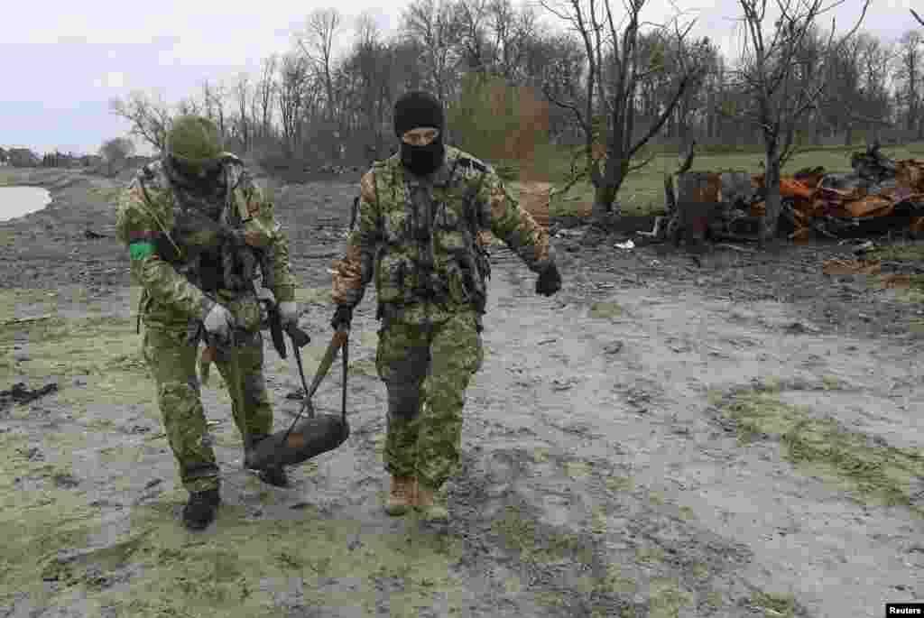 Zapadores ucranianos sacan un proyectil sin explotar de un tanque destruido cerca de Motyzhyn, un pueblo al oeste de Kiev, el 10 de abril.