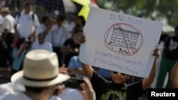 A demonstrator holds a placard reading: "No wall. Respect to immigrants and human rights" during a protest against U.S. President Donald Trump's proposed border wall and to call for unity, in Monterrey, Mexico, February 12, 2017.