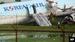 A security guard walks beside a damaged Korean Air plane after it overshot the runway at the Mactan-Cebu International Airport in Cebu, central Philippines, Oct. 24, 2022. The plane overshot the runway while landing in bad weather. Authorities said all 173 people on board survived.