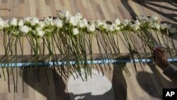 Un policía deposita flores durante una ceremonia por las víctimas del ataque a una guardería en la localidad rural de Uthai Sawan, en el noreste de Tailandia, el 7 de octubre de 2022. (AP Foto/Sakchai Lalit)