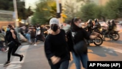 زنان معترض در تهران در حال گریز از چنگ ماموران موتورسوار.