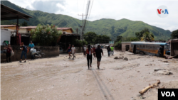 Entre lodo y agua vecinos de Maracay, Venezuela, intentan recuperar lo que queda tras aluvión