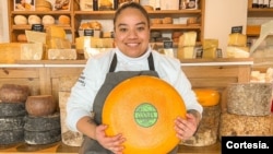 La venezolana Genessi Pinto muestra una bola de queso. [Foto cortesía]