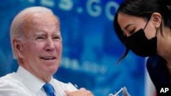 President Joe Biden gets his COVID-19 booster from a White House medical unit member in the South Court Auditorium on the White House campus in Washington, Oct. 25, 2022.