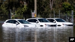 A trio of cars are stuck in floodwaters in Shepparton, Australia, Monday, Oct. 17, 2022. A flood emergency continues across parts of Australia's southeast. (Diego Fedele/AAP Image via AP)