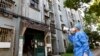 A volunteer uses a megaphone to talk to residents at an apartment building in Shanghai, China, April 12, 2022. (Xinhua News Agency via AP)