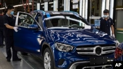 資料照 - 2020年5月在北京的北京奔馳汽車有限公司的汽車裝配線上，工人正在檢查裝配中的奔馳轎車。