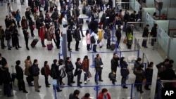 资料照片: 上海浦东国际机场候机大厅，旅客在排队办理登记手续