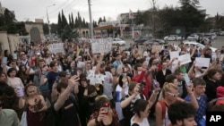  FILE - Young protesters use the light from their phones during an anti-war demonstration in memory of the victims of fighting in Ukraine, in front of Ukrainian Embassy in Tbilisi, Georgia, April 3, 2022.

