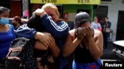 Mujeres reaccionan al reconocer a sus familiares detenidos que están siendo trasladados a una prisión después de que el Congreso de El Salvador aprobara reformas penales tras 89 asesinatos denunciados, durante el fin de semana en San Salvador, El Salvador, el 1 de abril de 2022
