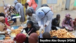 Des jeunes distribuent le Ndogou à Dakar. (VOA/Seydina Aba Gueye)
