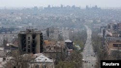 FILE - FILE PHOTO: A view shows damaged buildings, with the Azovstal Iron and Steel Works plant in the background, in the southern port city of Mariupol, Apr. 19, 2022.