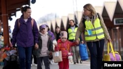 FILE - Ukrainian refugees walk on the platform after arriving on a train from Odesa at Przemysl Glowny train station, after fleeing the Russian invasion of Ukraine, in Przemysl, Poland, April 10, 2022.
