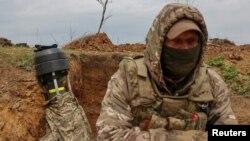 ཡུག་ཀེ་རན་གྱི་དམག་འཐབ་པ་ཞིག་དང་ཁོང་གི་ལྕགས་ཁྲབ་འཁོར་ལོ་གཏོར་བྱེད་ཀྱི་མཚོན་ཆ།