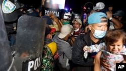 Las fuerzas de seguridad hondureñas tratan de evitar que los migrantes que intentan llegar a Estados Unidos crucen la frontera en El Florido, Honduras, hacia Guatemala, el viernes 15 de enero de 2021 a última hora.