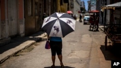 Una mujer se protege con un paraguas en La Habana, el 5 de julio de 2023. Hubo temperaturas récord durante los dos días no oficiales más calurosos registrados -el lunes y el martes- según la Universidad de Maine en EEUU.