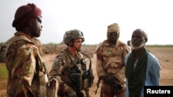 FILE - Malian Armed Forces (FAMa) and French soldiers of the "Belleface" Desert Tactical Group (GTD) conduct an area control operation in the Gourma region during the Operation Barkhane in Ndaki, Mali, July 29, 2019.