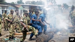 Policiers et soldats dégagent la rue barrée par des barricades, Bujumbura, 25 mai 2015.