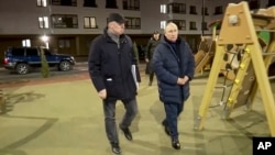 En esta foto tomada de un video publicado por Russian TV Pool el 19 de marzo de 2023, el presidente ruso Vladimir Putin (der) acompañado por el viceprimer ministro ruso Marat Khusnullin, visita Mariúpol en la región de ucraniana de Donetsk controlada por Rusia (Pool vía AP)