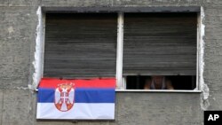 Čovek na prozoru stana tokom trajanja 60 sati dugog policijskog časa u Beogradu, 10 aprila 2020. (AP Photo/Darko Vojinović)