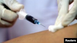 A health worker collects blood from a patient at an HIV/AIDS consulting centre while U.S. Health Secretary Mike Leavitt visits the centre in Vietnam's northern Hai Phong City, 92 km east of Hanoi October 15, 2005. 