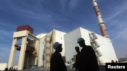 资料照：伊朗工人站在布什尔核电站前。