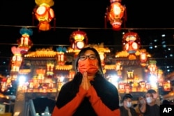 A woman offers prayer at the Wong Tai Sin Temple, Jan. 21, 2023, in Hong Kong, to celebrate the Lunar New Year which marks the Year of the Rabbit in the Chinese zodiac.