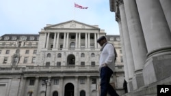 A man walks down steps in front of the Bank of England in London, Thursday, Feb. 2, 2023. (AP Photo/Frank Augstein)