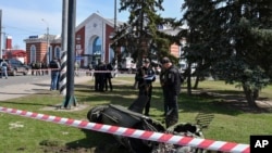 Wanajeshi wa Ukraine wakiwa pembeni ya kipande cha kombora la Tochka-U baada ya tukio la Russia kulipiga katika kituo cha reli huko mjini Kramatorsk, Ukraine, Ijumaa, April 8, 2022. (AP Photo/Andriy Andriyenko)