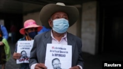 Los manifestantes sostienen hojas con una foto de la Fiscal General de Guatemala, María Consuelo Porras, durante una protesta contra su reelección frente a la Corte Suprema de Justicia en la Ciudad de Guatemala, Guatemala, el 6 de abril de 2022.