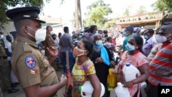 Des Sri Lankais attendent dans une station-service après avoir fait la queue pendant des heures pour acheter du kérosène à Colombo, au Sri Lanka, le 7 avril 2022. 