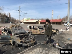 A man walks past burned cars at the site of a missile strike, at a rail station, amid Russia's invasion of Ukraine, in Kramatorsk, Ukraine April 8, 2022. REUTERS/Stringer
