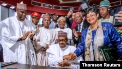 Rais wa Nigeria, Muhammadu Buhari akitia saini mkataba wa biashara huru Afrika kwenye mkutano wa AU mjini Niamey, Niger